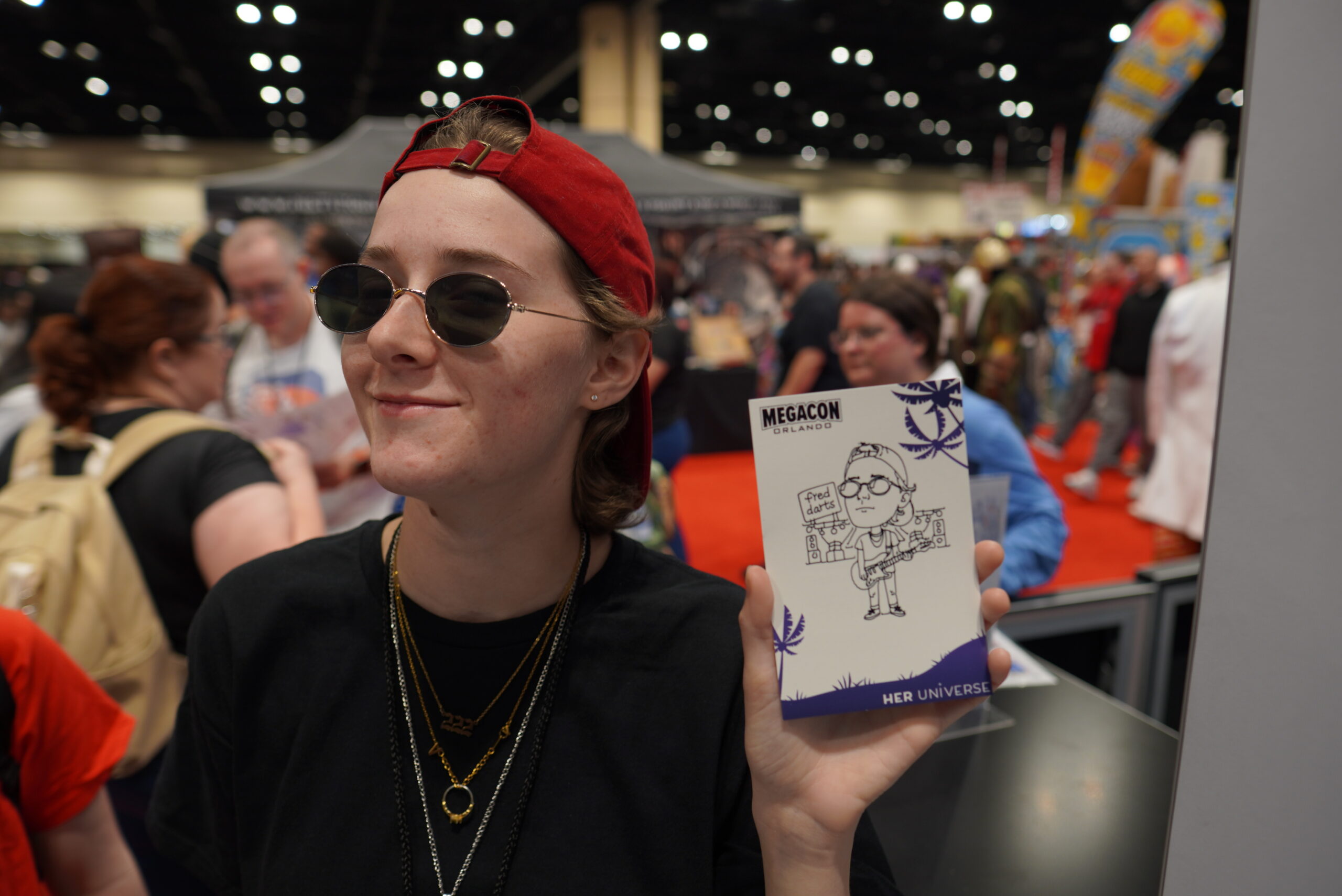 MegaCon Orlando guest holding a personalized Draw Me Bot robotic caricature with custom branded portrait artwork by BOMBA Creative Co.